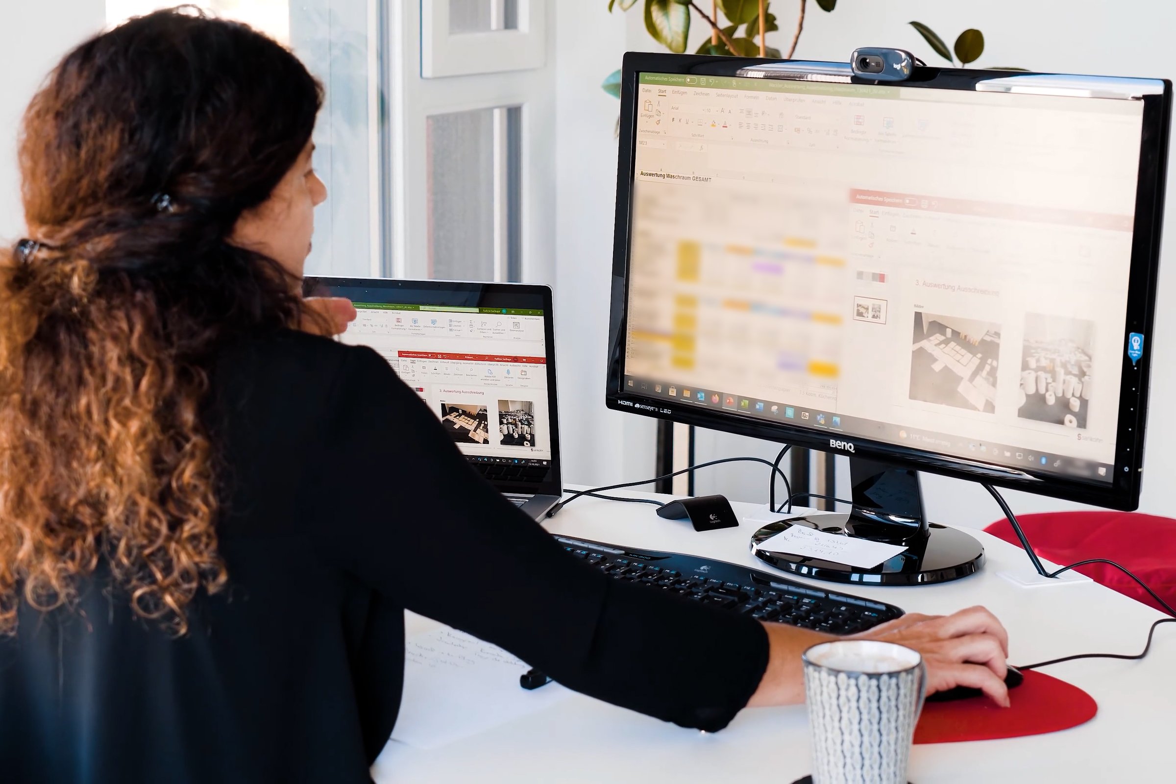 Arbeitsplatz mit Bildschirm und Laptop, auf dem Bildschirm die Auswertung eines Waschraumsortiments
